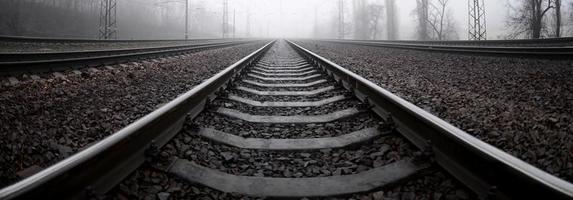 The railway track in a misty morning. A lot of rails and sleepers go into the misty horizon. Fisheye photo with increased distortion