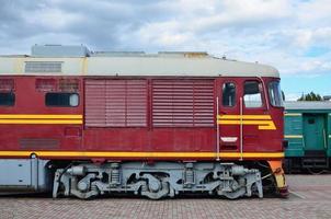 cabina del moderno tren eléctrico ruso. vista lateral de la cabeza del tren ferroviario con muchas ruedas y ventanas en forma de ojos de buey foto