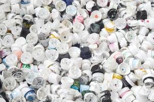 A pattern of many used and soiled nozzles from spray cans with aerosol paint. Background texture of the street art of drawing graffiti on the walls photo