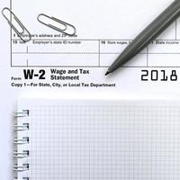 el bolígrafo y el cuaderno en el formulario de impuestos w-2 declaración de salarios e impuestos. la hora de pagar impuestos foto