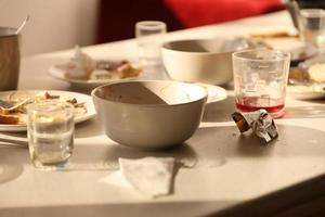 platos sucios vacíos con cucharas y tenedores en la mesa después de la comida. concepto de final de banquete. platos sin lavar foto