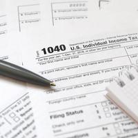 The pen and notebook is lies on the tax form 1040 U.S. Individual Income Tax Return. The time to pay taxes photo