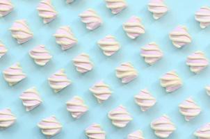 Colorful marshmallow laid out on blue paper background. pastel creative textured pattern. minimal photo