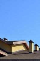 Modern roofing and decoration of chimneys. Flexible bitumen or slate shingles. The absence of corrosion and condensation due to the flexible roof photo