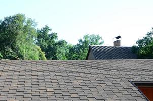 Modern roofing and decoration of chimneys. Flexible bitumen or slate shingles photo