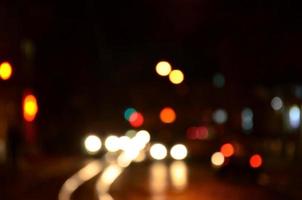 Blurred night scene of traffic on the roadway. Defocused image of cars traveling with luminous headlights. Bokeh Art photo