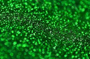 A huge amount of green decorative sequins. Background image with shiny bokeh lights from small elements photo