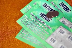 Close up view of green lottery scratch cards. Many used fake instant lottery tickets with gambling results. Gambling addiction photo