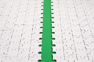 The green path is laid on the platform of a white folded jigsaw puzzle. Texture image with copy space for text photo