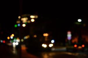 Blurred night scene of traffic on the roadway. Defocused image of cars traveling with luminous headlights. Bokeh Art photo