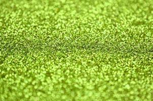 Lime green decorative sequins. Background image with shiny bokeh lights from small elements photo