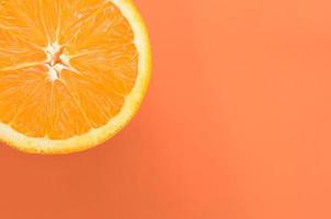 Top view of a one orange fruit slice on bright background in orange color. A saturated citrus texture image photo