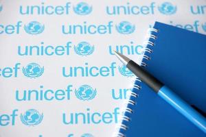 TERNOPIL, UKRAINE - MAY 2, 2022 Blue notepad and pen from UNICEF - United Nations programm that provides humanitarian and developmental assistance to children photo