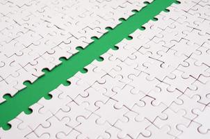 The green path is laid on the platform of a white folded jigsaw puzzle. Texture image with copy space for text photo