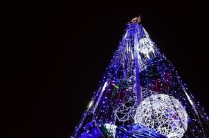 fragmento del árbol de año nuevo. muchas luces redondas de color azul están ubicadas en un marco cónico foto