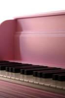 Close-up of the keyboard of a pink piano. Set of white and black buttons photo