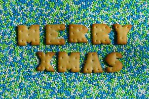 Merry Xmas. The word from the edible letters lies on the glazed powder photo