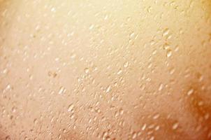 Background image of rain drops on a glass window. Macro photo with shallow depth of field. Toned picture