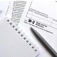 el bolígrafo y el cuaderno en el formulario de impuestos w-2 declaración de salarios e impuestos. la hora de pagar impuestos foto