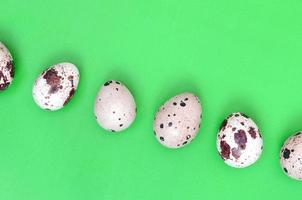 Quail eggs on a light green surface, top view, empty place for t photo