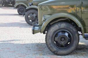 Photo of the cabins of three military off-road vehicles from the times of the Soviet Union. Side view of military cars from the front wheel