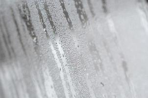 The texture of a misted glass with a lot of drops and condensation flows. Background image photo