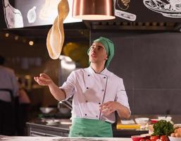 chef throwing up pizza dough photo