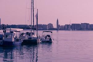 A photograph of a ship and a luxury yacht anchored in port. Beautiful photo of a Mediterranean port