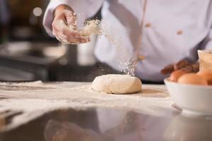 chef hands preparing dough for pizza photo