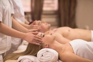 couple enjoying head massage at the spa photo