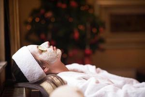woman is getting facial clay mask at spa photo