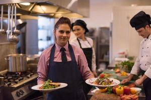 young waitress showing dishes of tasty meals photo