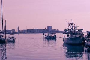 A photograph of a ship and a luxury yacht anchored in port. Beautiful photo of a Mediterranean port