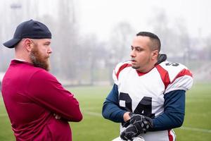 american football player discussing strategy with coach photo