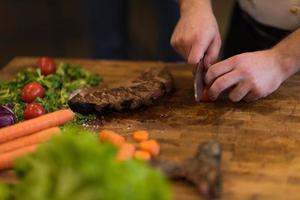 closeup of Chef hands preparing beef steak photo