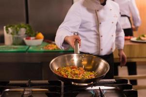 chef flipping vegetables in wok photo