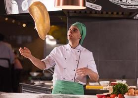 chef throwing up pizza dough photo