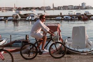 pareja mayor disfrutando de una hermosa mañana juntos montando en bicicleta junto al mar. enfoque selectivo foto