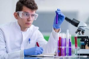 student with protective glasses making chemistry experiment photo