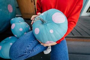 closeup of a young woman holding an ornate pumpkin photo