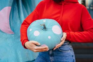 closeup of a young woman holding an ornate pumpkin photo