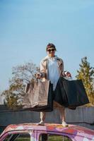 A young woman is standing in a car with bags in her hands photo