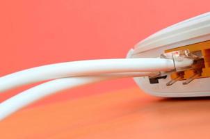 The Internet cable plugs are connected to the Internet router, which lies on a bright orange background. Items required for Internet connection photo