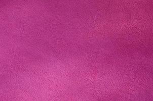 The blanket of furry pink fleece fabric. A background texture of light pink soft plush fleece material photo
