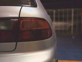 The rear of the car parked in the house fence at night. photo