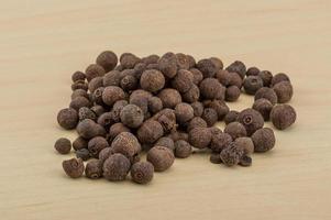 Black pepper on wooden background photo