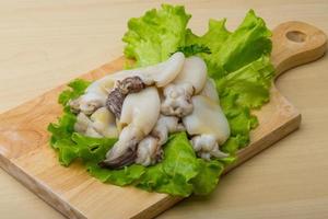 Raw cuttlefish on wooden board and wooden background photo