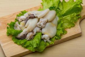 Raw cuttlefish on wooden board and wooden background photo