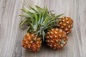 Small pineapple on wood photo