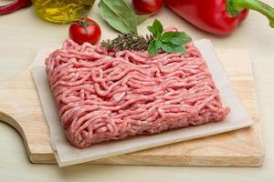 Minced meat on wooden board and wooden background photo